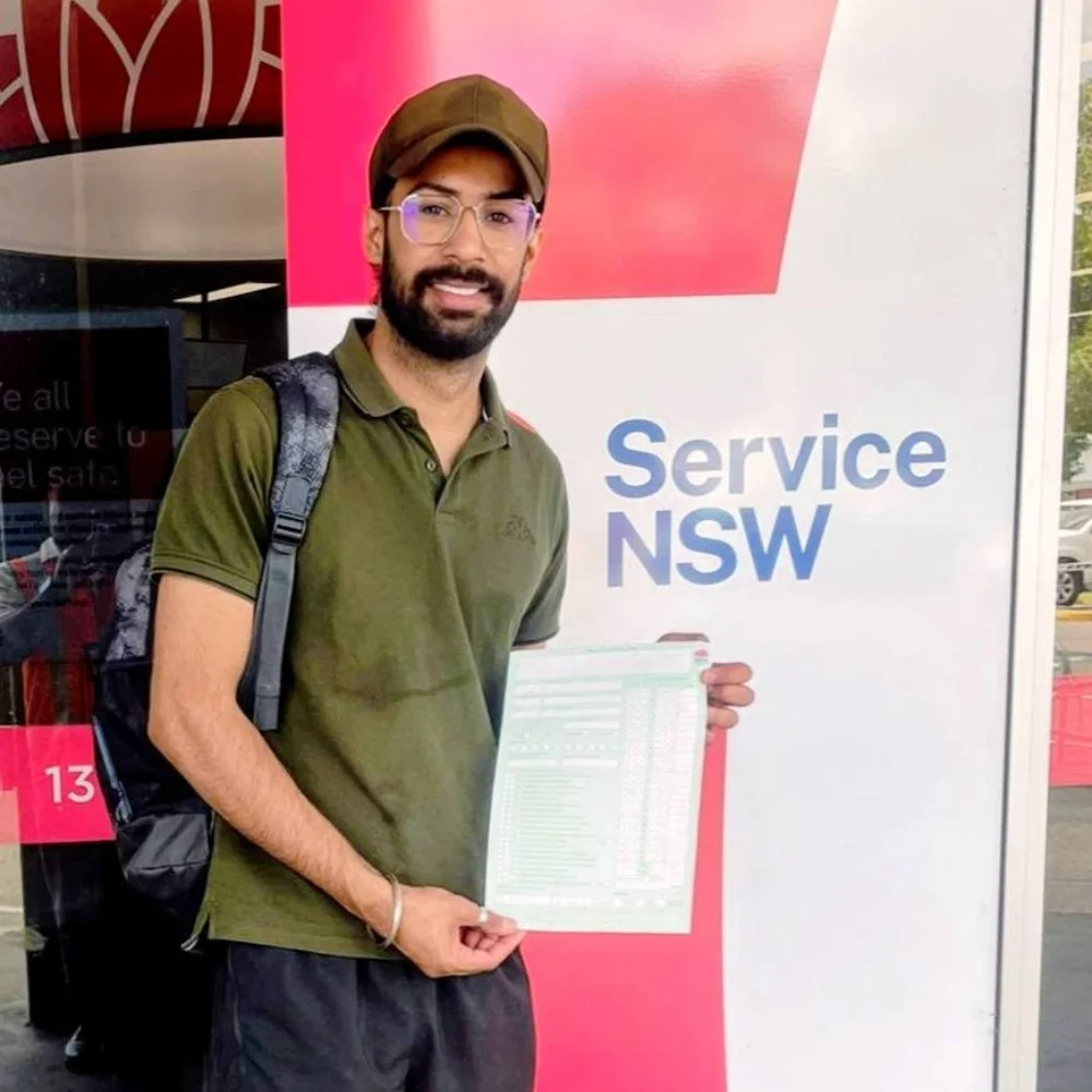 a guy smiling holding his driving license document